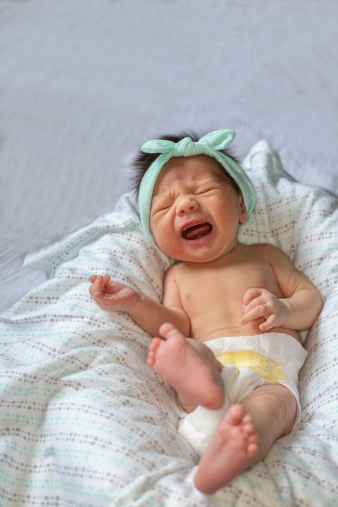 Weinendes Baby liegt im Bett