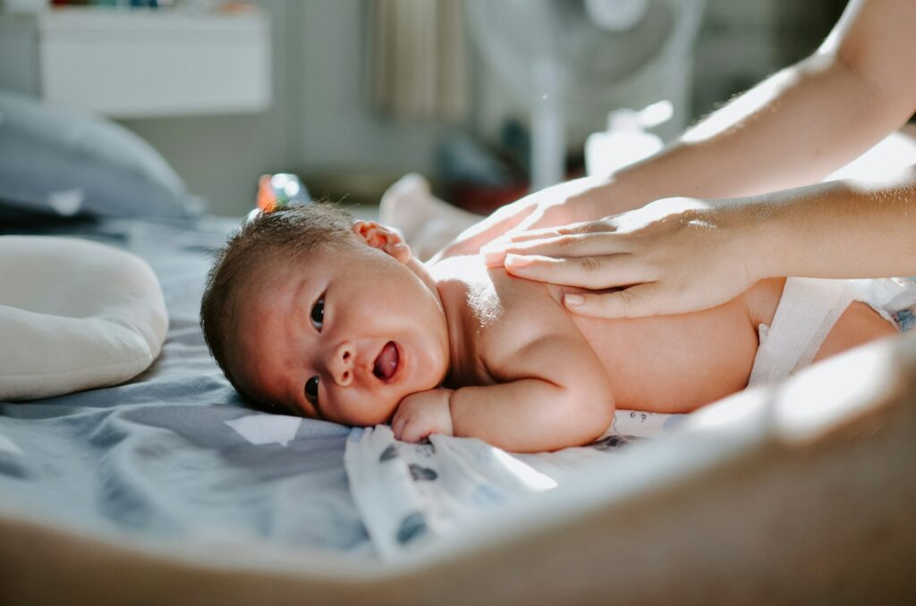 Mutter massiert sanft den Rücken ihres Babys