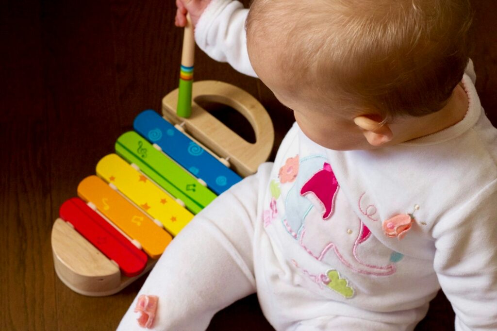 Baby spielt mit einem bunten Xylophon