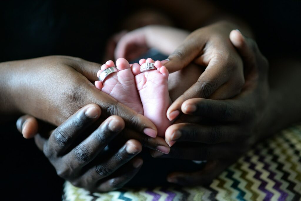 Kindergeld beantragen: Eltern berühren die Füße ihres Neugeborenen